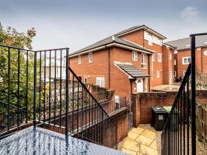 a fence in front of a brick building at Pass the Keys Central townhouse with parking and modern finish in Exeter