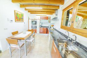a kitchen with a dining table and a sink at Finca Els Oscols 53 in Alcudia
