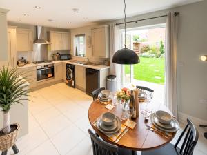 a kitchen and dining room with a table and chairs at Pass the Keys Contemporary 2 bedroom home in Ludlow