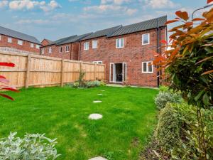 a yard with a fence and a brick house at Pass the Keys Contemporary 2 bedroom home in Ludlow