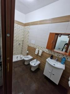 een badkamer met 2 wastafels, een toilet en een spiegel bij Appartamento Napoli ,casa vacanza e b&b in Napels