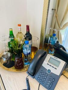 a desk with a phone and bottles of wine at MMA apartament in Klaipėda