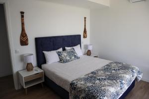 a bedroom with a large bed with a blue headboard at Villas da Salga in Angra do Heroísmo