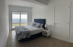 a bedroom with a bed with a view of the ocean at Villas da Salga in Angra do Heroísmo