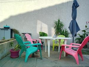 a table with colorful chairs and an umbrella at une maison en ville in Saint-Denis