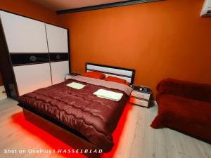 Un dormitorio con una cama y una pared roja. en Тристаен апартамент в центъра, en Sofía