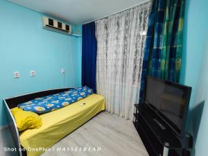 Un pequeño dormitorio con una cama y un televisor. en Тристаен апартамент в центъра, en Sofía