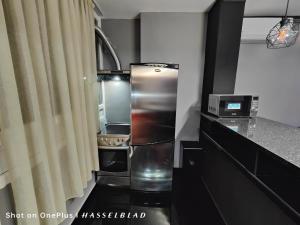 Una cocina con refrigerador de acero inoxidable en una habitación. en Тристаен апартамент в центъра, en Sofía