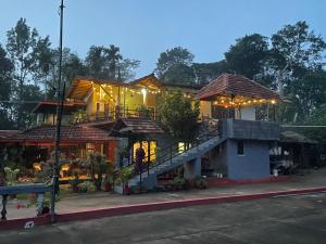 a house with a staircase in front of it at Coorg Sai Estate Ecobreeze Homestay in Madikeri