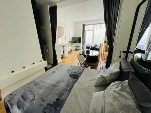 a bedroom with a large bed and a living room at Le refuge du 15 in Paris