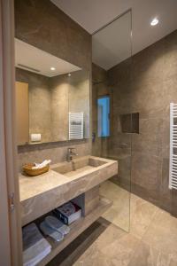 y baño con lavabo y ducha acristalada. en Duomo Resort en Shkodër