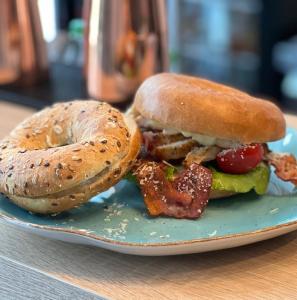 a sandwich and a bagel on a plate at Ośrodek Wypoczynkowy Wiga in Kołobrzeg