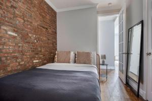 um quarto com uma parede de tijolos e uma cama em East Village 2br w wd nr union square NYC-1260 em Nova York