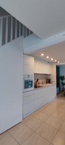 eine Küche mit weißen Schränken und einer Arbeitsplatte in der Unterkunft L'inattendue - Maison centre ville - Dourdan in Dourdan