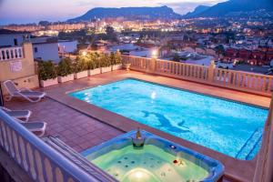 a swimming pool on a balcony with a view of a city at Villas Guzman - BELLISSIMA in Calpe
