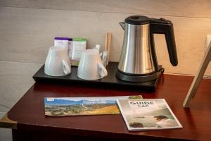 a coffee maker and a magazine on a table at Hotel Beau Rivage in Aix-les-Bains