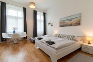 a bedroom with a bed and a table with chairs at Washingtonova CR apartments in Prague