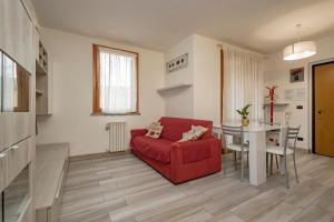 ein Wohnzimmer mit einem roten Sofa und einem Tisch in der Unterkunft Bomboniera Milano zona RHO FIERA - Bilocale 70mq in Senago