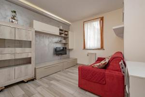een woonkamer met een rode bank en een televisie bij Bomboniera Milano zona RHO FIERA - Bilocale 70mq in Senago