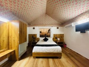 1 dormitorio con 1 cama y TV de pantalla plana en Santkrupa Villa Resort en Nakhtrana