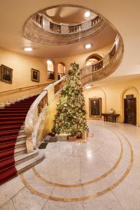 a christmas tree in a building with a staircase at The Royal Horseguards Hotel, London in London