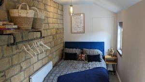 una camera da letto con un muro di mattoni e un letto blu di The Pudding Stop - Bakewell - Free Parking a Bakewell