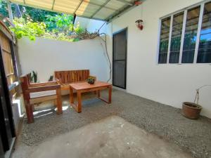 a patio with a bench and a table and a window at Gensan Homey Apartment in General Santos