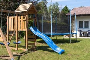 a playground with a blue slide and a wooden structure at Flauta Apartamenty Rodzinne in Mielenko
