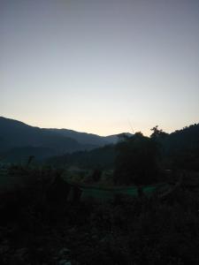 a view of a mountain with the sun setting at Pame Farm Stay in Pokhara