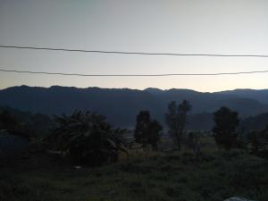 a view of the mountains from a field at Pame Farm Stay in Pokhara