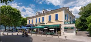 a person riding a bike in front of a hotel at Hotel Beau Rivage in Aix-les-Bains