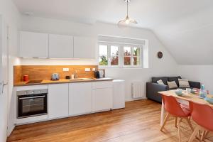 eine Küche und ein Wohnzimmer mit einem Tisch und einem Sofa in der Unterkunft L'Escale de la baie ! in Pontorson