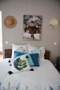 1 dormitorio con 1 cama con almohadas azules y blancas en Aux portes de Pornichet, Chambres d'hôtes Ty'Sacha en Saint-Nazaire