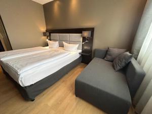 a bedroom with a large bed and a couch at Hotel am Karlstor in Karlsruhe