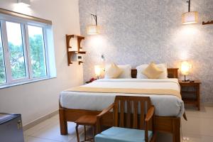 Un dormitorio con una cama grande y una ventana en AURA HOTEL, en Pondicherry