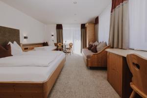 une chambre d'hôtel avec un lit et un canapé dans l'établissement B&B Hotel Die Bergquelle, à Flachau