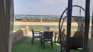 un patio con mesa y sillas y vistas a la playa en Seaview Chalets in Porto South Beach - Families only, en Ain Sokhna