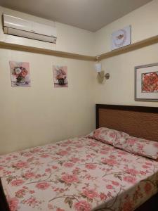 1 dormitorio con 1 cama con colcha de flores en Seaview Chalets in Porto South Beach - Families only, en Ain Sokhna