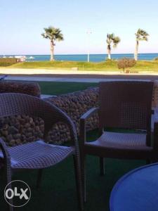 2 sillas y una mesa con vistas al océano en Seaview Chalets in Porto South Beach - Families only, en Ain Sokhna