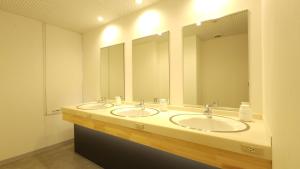 a bathroom with two sinks and two mirrors at Acro Capsule Hotel Namba Dotonbori in Osaka