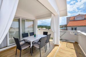 a dining room with a table and chairs on a balcony at Apartments Jasna in Primošten
