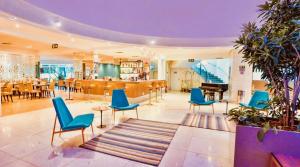 a living room with blue chairs and a piano at FLAT HOTEL BEIRA MAR AV BOA VIAGEM Recife in Recife