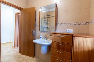 a bathroom with a sink and a mirror at Chalé d'Angra Guest House in Angra do Heroísmo