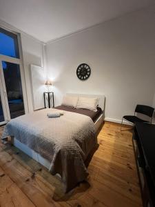 a bedroom with a bed and a clock on the wall at Guest house Heysel Laeken Atomium in Brussels