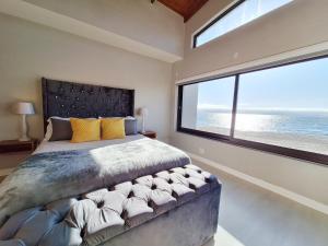 una camera da letto con un grande letto con una grande finestra di Beyond Beautiful Beach House a Langstrand