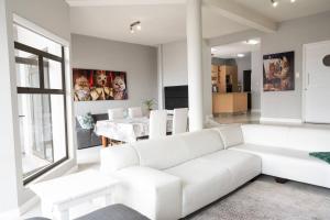 uma sala de estar branca com um sofá branco e uma mesa em Beyond Beautiful Beach House em Langstrand
