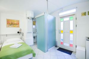 Habitación pequeña con cama y baño. en Tiny central studio apartment Tour As Ljubljana, en Liubliana