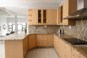 uma cozinha com armários de madeira e bancadas de granito em Beyond Beautiful Beach House em Langstrand