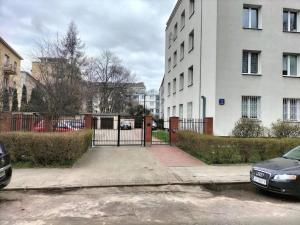 ein Parkplatz mit einem Tor vor einem Gebäude in der Unterkunft Urbannestgroup - Angorska przy Stadionie Narodowym in Warschau