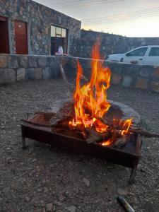 a fire pit with flames in front of a building at Stone rest house jebel shams in Al Ḩamrāʼ